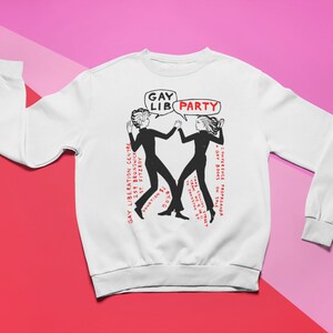 May include: White sweatshirt with a black and white illustration of two people dancing with the text "GAY LIB PARTY" in a speech bubble above them. The text "GAY LIBERATION CENTRE 259 BRUNSWICK ST FITZROY DONATION $400 GAY BOOKS ON SALE CONFERENCE PROPAGANDA" is printed on the right side of the sweatshirt.