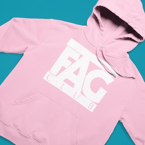 Peut inclure: Un sweat à capuche rose avec un motif blanc qui dit "F.A.G. CLUB" en majuscules.