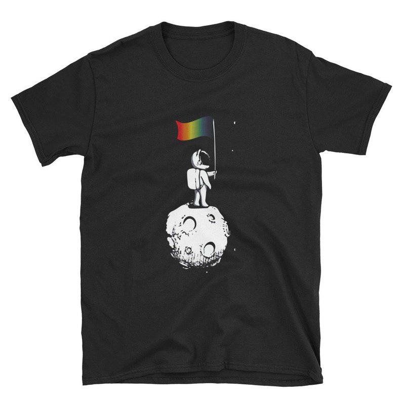 May include: A black t-shirt featuring a graphic of an astronaut standing on the moon holding a rainbow flag.