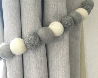 Grijze en witte vilten bolletjes gordijnbandjes: wollen pomponsdecor