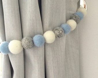 Blauwe vilten bolletjes gordijnbandjes: babyblauwe gordijnbandjes