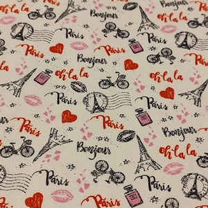 May include: A white fabric with a repeating pattern of black and red Parisian themed illustrations. The pattern includes the Eiffel Tower, bicycles, hearts, lips, stars, and the words "Paris", "Bonjour", and "Oh la la".