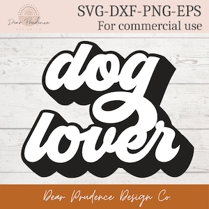 May include: A black and white graphic design with the words "dog lover" in a bold, stylized font. The design includes the text "SVG-DXF-PNG-EPS For commercial use" and the logo "Dear Prudence Design Co."