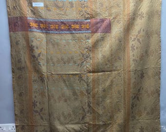 Op de afbeelding: Een rechthoekig textiel met een beige basis, een subtiel bloemenpatroon en verticale strepen. De stof vertoont horizontale banden in gedempt rood en oranje met decoratieve stiksels. Een klein wit label met de tekst VQ2327 is bevestigd.