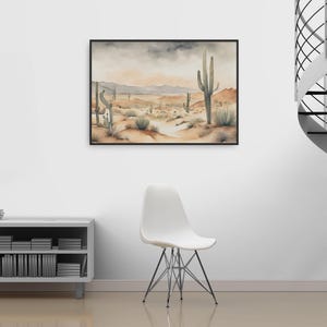 Minimalist charm fills the living space, where a white chair and silver bookshelf are paired with a striking beautiful watercolor desert landscape painting that completes the ambiance