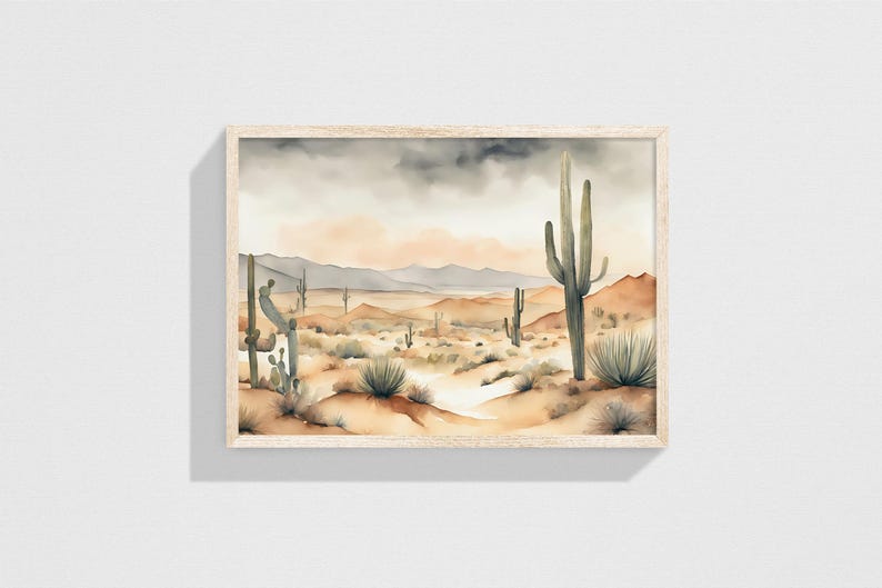 Framed in light oak wood, the beautiful watercolor desert landscape painting adds a touch of artistry to the muted grey wall it adorns
