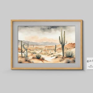 On a smooth, grey wall, the beautiful watercolor desert landscape artwork is beautifully presented within a textured contemporary wooden frame in rich brown tones