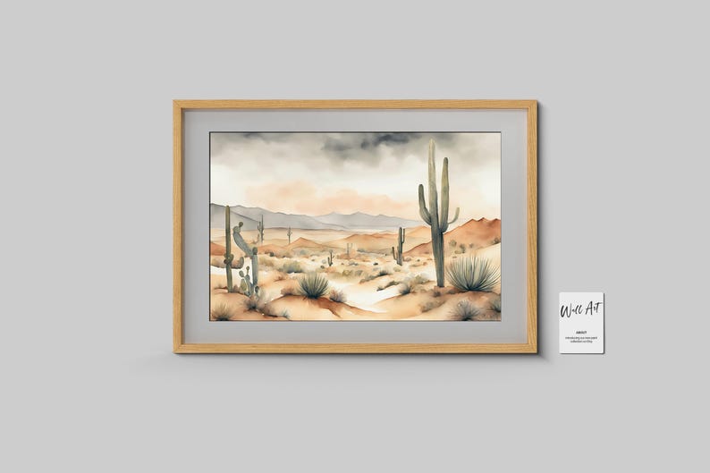 On a smooth, grey wall, the beautiful watercolor desert landscape artwork is beautifully presented within a textured contemporary wooden frame in rich brown tones