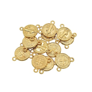 May include: A pile of gold-colored metal charms with a religious design. Each charm has a cross and a figure of a saint. The charms have three loops for attaching to a necklace or bracelet.