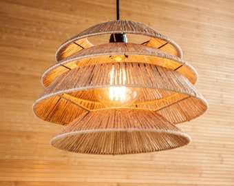 May include: A woven pendant light fixture with a natural beige color and a warm light bulb. The light fixture is hanging from a black cord against a wood background.