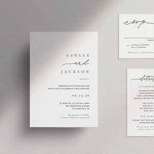 May include: A set of three minimalist wedding stationery cards. The main card features the names "Ashley and Jackson" in elegant script. Additional cards include an RSVP and details card, all in black text on a white background.