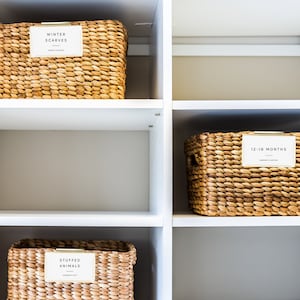 May include: White shelves with four woven baskets labeled "Winter Scarves", "Stuffed Animals", "12-18 Months", and empty.