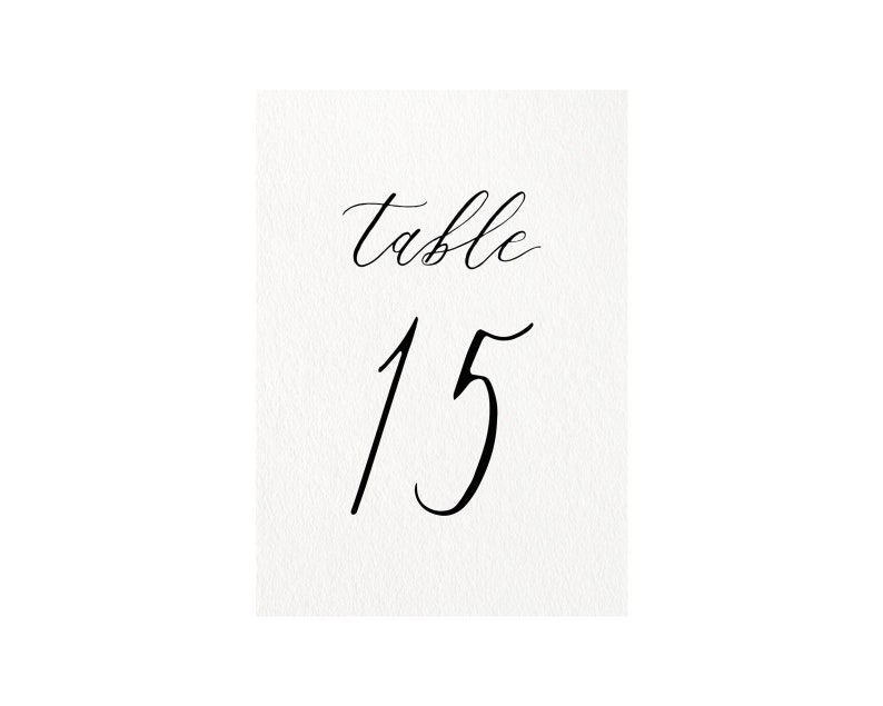 以下が含まれることがあります： 白いカードに黒い書体で「テーブル15」と書かれています。