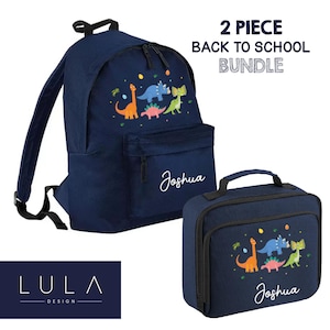 May include: A navy blue backpack and matching lunch bag set featuring a colorful dinosaur print and the name Joshua in white script. The text 2 PIECE BACK TO SCHOOL BUNDLE appears at the top, and the LULA DESIGN logo is in the bottom corner.
