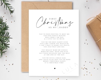 May include: A white greeting card with the text "First Christmas as my Daddy" in elegant script. The card includes a heartfelt message and is accompanied by a brown envelope and a wrapped gift, perfect for the holiday season.