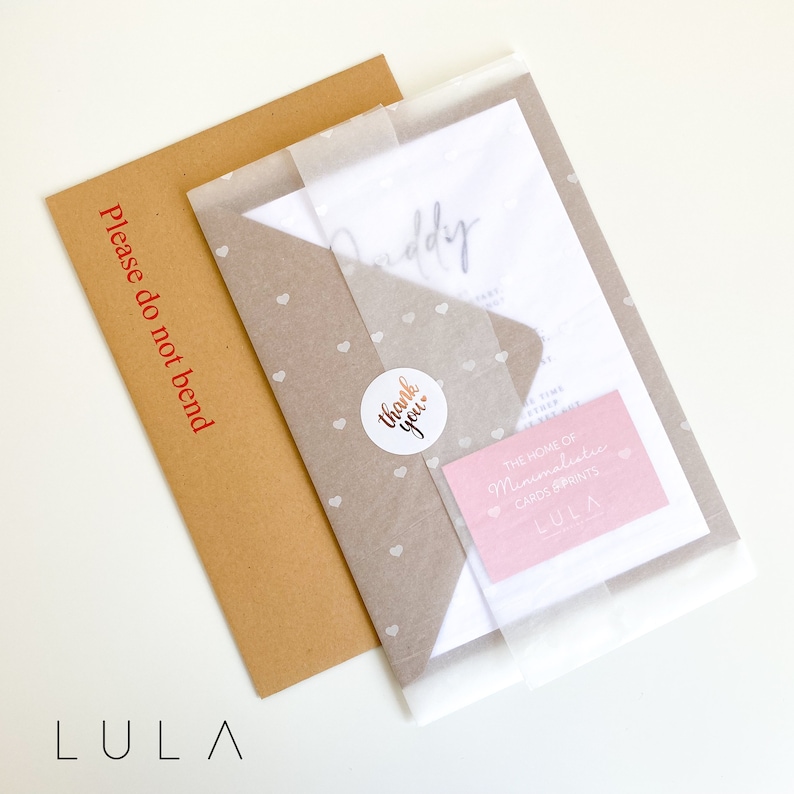 May include: A white envelope with a brown envelope inside. The white envelope has a pink card with the text "The home of Minimalistic Cards Prints LULA" and a sticker that says "Thank you". The brown envelope has the text "Please do not bend" printed on it.