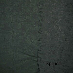 May include: A close-up of a dark green fabric with a subtle, swirling pattern. The fabric has a smooth texture and a slightly sheen finish. The word "Spruce" is printed in white at the bottom of the image.