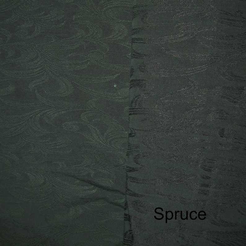May include: A close-up of a dark green fabric with a subtle, swirling pattern. The fabric has a smooth texture and a slightly sheen finish. The word "Spruce" is printed in white at the bottom of the image.