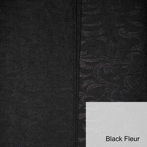 May include: Black fabric with a subtle embossed pattern. One side of the fabric is smooth, while the other side has a raised pattern. The fabric is labeled "Black Fleur".