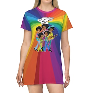 May include: A rainbow-colored t-shirt dress featuring a cartoon illustration of the Jackson 5 band members. The band members are wearing colorful outfits and are walking in a line. The text "Jackson 5" is written in white on a black background.