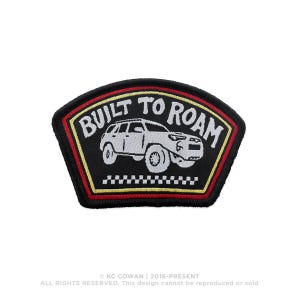 May include: Black patch with the text "BUILT TO ROAM" and an illustration of a white SUV. The patch has a black background with red and yellow borders. A small checkered pattern is at the bottom.