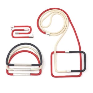 May include: A collection of colorful cord accessories, including a red and white cord, a red and black cord, and a set of three half-circle cords in red, white, and black. Each piece features silver metal accents.