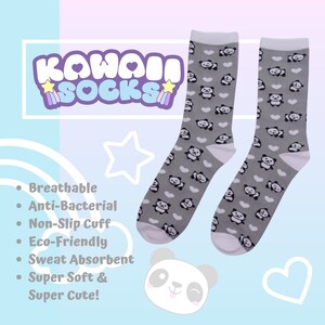 K&ouml;nnte beinhalten: Ein Paar graue Socken mit einem wei&szlig;en Panda- und Herz-Druck. Die Socken sind atmungsaktiv, antibakteriell und haben einen rutschfesten Bund. Der Text "Kawaii Socks" befindet sich in der oberen linken Ecke des Bildes.