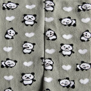 K&ouml;nnte beinhalten: Graue Strumpfhosen mit einem sich wiederholenden Muster aus wei&szlig;en Herzen und schwarz-wei&szlig;en Pandab&auml;ren. Die Pandas l&auml;cheln und haben schwarze Augen.
