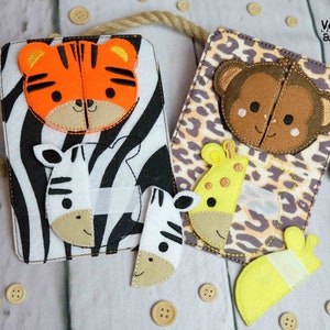 Op de afbeelding: Twee dierenpuzzels van vilt met een tijger, zebra, aap en giraffe. De tijger- en zebrapuzzel heeft een zwart-witte zebraprint achtergrond. De aap- en giraffenpuzzel heeft een bruin en beige luipaardprint achtergrond. De tekst "Verstempelt & Zugenaht" staat op de aap- en giraffenpuzzel.