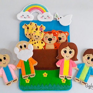 Pode incluir: Marionetes de dedo de feltro de um homem com barba, uma mulher com cabelo grisalho, um menino, uma menina, duas girafas e dois tigres. As marionetes est&atilde;o dispostas em frente a um fundo de feltro azul com um arco-&iacute;ris e uma pomba branca. O fundo tamb&eacute;m tem um bolso de feltro marrom com grama verde e flores amarelas.