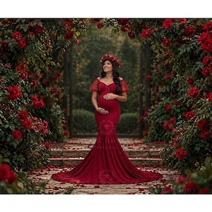 May include: A floor-length, deep red maternity dress featuring a sweetheart neckline, short sheer sleeves, and a fitted bodice that flares into a long train. The garment is paired with a matching floral crown made of red roses and green leaves.