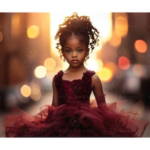 Può includere: Una bambina con i capelli castano scuro indossa un vestito bordeaux con un motivo floreale e si trova in piedi davanti a uno sfondo sfocato di luci dorate.