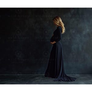 May include: A pregnant woman wearing a long black maxi dress with a fitted bodice and a flowing skirt. She is standing in front of a dark gray textured wall.