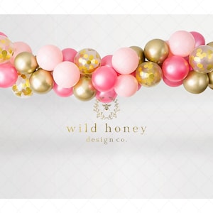 May include: A pink and gold balloon garland with confetti balloons. The garland is hanging from the ceiling and is decorated with pink and gold balloons. The text "wild honey design co." is printed below the garland.