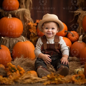 May include: A smiling child wearing a hat and overalls sits among pumpkins and hay. The scene is set for autumn, with orange pumpkins of various sizes and dried leaves. The background features the text "wild honey design co."