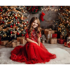 Könnte beinhalten: Ein junges Mädchen in einem roten Tüllkleid mit Pailletten sitzt auf einem weißen Kunstfellteppich vor einem Weihnachtsbaum, der mit Lichtern und Ornamenten geschmückt ist. Im Hintergrund befinden sich verpackte Geschenke.