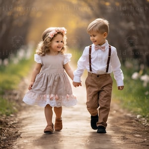 May include: A young girl in a beige dress with pink floral accents holds hands with a young boy wearing a white shirt, brown trousers, and a pink bow tie. They are walking along a path in a garden setting.