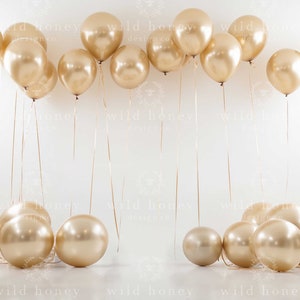 Könnte beinhalten: Ein weißer Hintergrund mit einer Reihe goldener Ballons, die von der Decke hängen, und einer Gruppe goldener Ballons auf dem Boden.