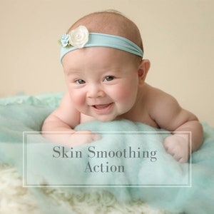 Peut inclure: Un bébé portant un bandeau bleu clair avec des fleurs blanches, allongé sur une couverture bleu clair. Le bébé sourit et regarde la caméra. Le texte "Skin Smoothing Action" est écrit sur la couverture.