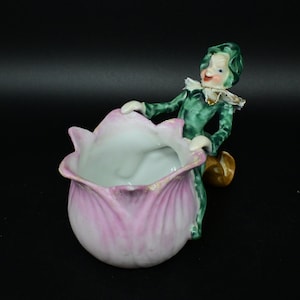 Vintage ceramic Pixie sitting on the stem of a flower planter