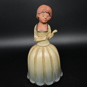 Elegant damfigur i röd keramik som fungerar som en klocka från Uctci Japan