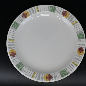May include: A white ceramic dinner plate with a green, yellow and brown geometric pattern around the rim.