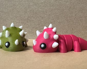 Figure di triceratopo articolate stampate in 3D, cactus e coppia rosa