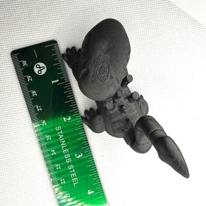 Puede incluir: Figurita de drag&oacute;n negro impresa en 3D. El drag&oacute;n est&aacute; en posici&oacute;n de pie con la cola enroscada alrededor de su cuerpo. El drag&oacute;n mide aproximadamente 7,6 cm de alto.