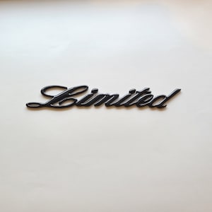 May include: Black plastic "Limited" emblem with a cursive font.