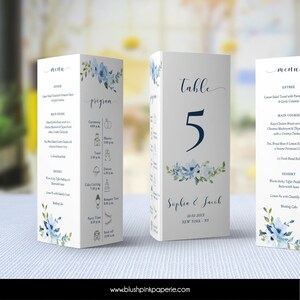 Könnte beinhalten: Weißes Tischkärtchen mit der Nummer 5 in Dunkelblau, blauen Blumenmotiven und den Namen Sophia & Jacob. Teil eines Hochzeitspapeterie-Sets mit Menü und Programm.