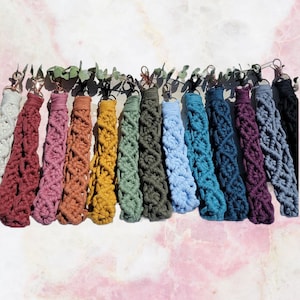 May include: A collection of 15 colorful macrame keychains with different colors and patterns. The keychains are made with cotton cord and have a metal ring at the top.