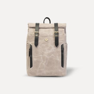 May include: A gray canvas backpack with black leather straps and buckles. The backpack has a roll-top closure and a small pocket on the front.