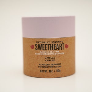 May include: A brown and pink deodorant container with the text "NATURALLY SENSITIVE SWEETHEART BAKING SODA FREE SANS BICARBONATE DE SOUDE VANILLA VANILLE ALL NATURAL DEODORANT DEODORANT TOUT NATUREL Net wt. 4oz./110g"