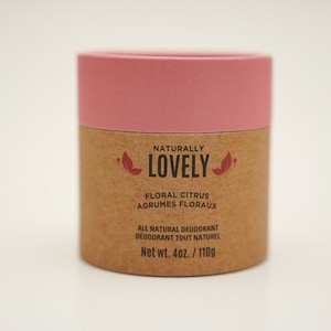 Peut inclure: Un tube en carton rose et brun avec le texte "NATURALLY LOVELY" et "FLORAL CITRUS AGRUMES FLORAUX" imprimé dessus. Le tube indique également "ALL NATURAL DEODORANT DEODORANT TOUT NATUREL" et "Net wt. 4oz./110g".